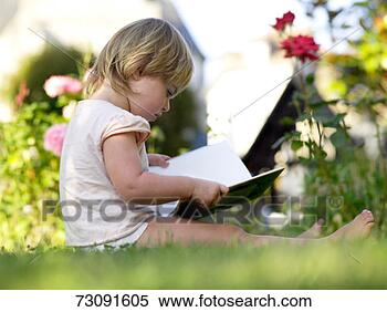 Stock Image - girl (2-3) sitting 
in garden, reading 
book, ground view. 
fotosearch - search 
stock photos, 
pictures, images, 
and photo clipart