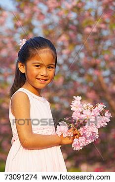 Stock Photo - girl (4-5) holding 
bunch of cherry 
blossoms in orchard, 
portrait. fotosearch 
- search stock 
photos, pictures, 
images, and photo 
clipart