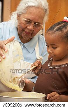 Stock Image - grandmother and 
granddaughter 
(3-5) in kitchen, 
 mixing ingredients. 
fotosearch - search 
stock photos, 
pictures, images, 
and photo clipart