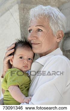 Stock Photo - grandmother holding 
grandchild (3-6 
months) outdoors. 
fotosearch - search 
stock photos, 
pictures, images, 
and photo clipart