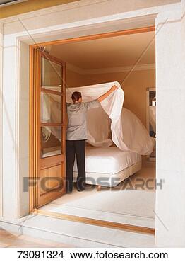 Stock Photo - maid preparing 
bed in hotel room, 
rear view. fotosearch 
- search stock 
photos, pictures, 
images, and photo 
clipart
