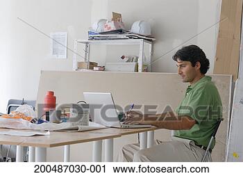 Stock Photography - male architect 
using laptop on 
makeshift desk 
in site office. 
fotosearch - search 
stock photos, 
pictures, images, 
and photo clipart