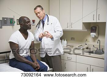 Stock Photo - male doctor explaining 
medicine to male 
patient in examination 
room. fotosearch 
- search stock 
photos, pictures, 
images, and photo 
clipart