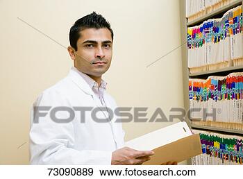 Stock Photograph - male doctor with 
file by filing 
cabinet, portrait. 
fotosearch - search 
stock photos, 
pictures, images, 
and photo clipart