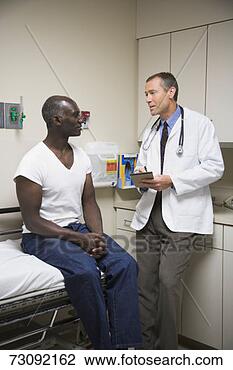 Stock Photo - male patient, 
sitting on examination 
table, talking 
to male doctor. 
fotosearch - search 
stock photos, 
pictures, images, 
and photo clipart