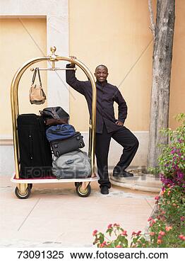 Stock Image - male porter with 
luggage trolley 
outside hotel, 
portrait. fotosearch 
- search stock 
photos, pictures, 
images, and photo 
clipart