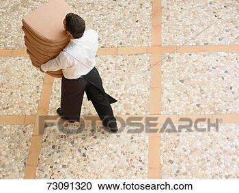 Stock Photography - man carrying seat 
cushions outdoors, 
elevated view. 
fotosearch - search 
stock photos, 
pictures, images, 
and photo clipart