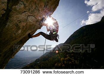 Stock Photo - man climbing rock 
overhang, low 
angle view. fotosearch 
- search stock 
photos, pictures, 
images, and photo 
clipart
