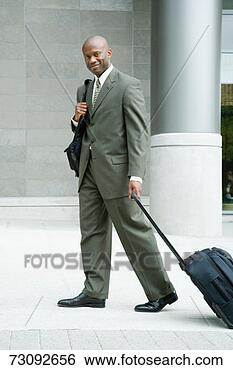 Stock Photo - mature business 
man walking with 
suitcase, smiling, 
portrait. fotosearch 
- search stock 
photos, pictures, 
images, and photo 
clipart