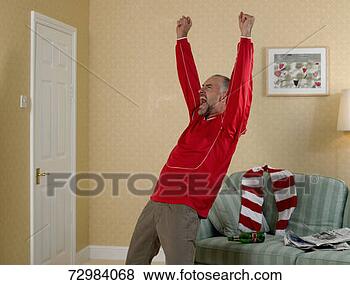 Stock Photo - mature football 
supporter at home 
raising fists 
in excitement. 
fotosearch - search 
stock photos, 
pictures, images, 
and photo clipart