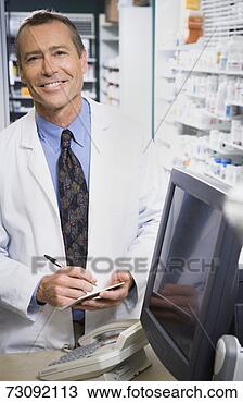 Stock Photo - mature male pharmacist, 
smiling, writing 
note, portrait. 
fotosearch - search 
stock photos, 
pictures, images, 
and photo clipart
