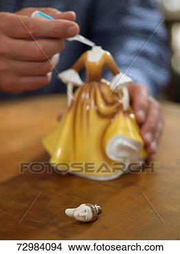 Stock Photo - mature man applying 
glue to neck of 
broken china figurine. 
fotosearch - search 
stock photos, 
pictures, images, 
and photo clipart