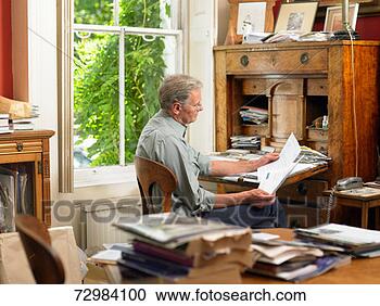 Stock Photography - mature man sitting 
at antique desk 
at home,  surrounded 
by books and. 
fotosearch - search 
stock photos, 
pictures, images, 
and photo clipart