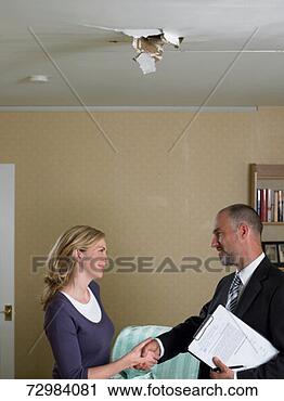 Stock Photography - mid adult woman 
shaking hands 
with mature man 
holding clipboard. 
fotosearch - search 
stock photos, 
pictures, images, 
and photo clipart
