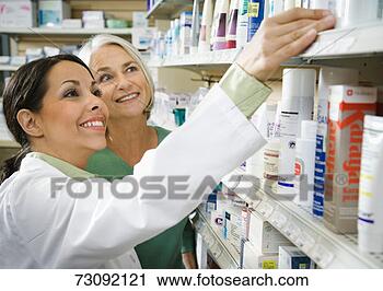 Stock Photography - pharmacist reaching 
to product on 
shelf,  assisting 
senior smiling. 
fotosearch - search 
stock photos, 
pictures, images, 
and photo clipart