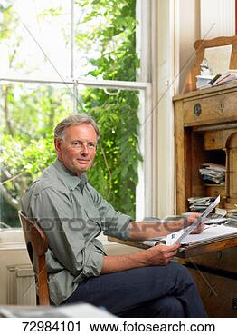 Stock Photography - portrait of mature 
man sitting by 
window at antique 
desk, portrait. 
fotosearch - search 
stock photos, 
pictures, images, 
and photo clipart