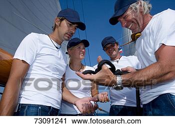 Stock Photography - sailboat captain 
holding knotted 
rope with crew 
watching. fotosearch 
- search stock 
photos, pictures, 
images, and photo 
clipart