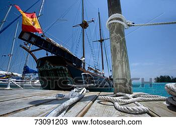 Stock Photo - sailboat moored 
by jetty, ropes 
in foreground, 
low angle view. 
fotosearch - search 
stock photos, 
pictures, images, 
and photo clipart
