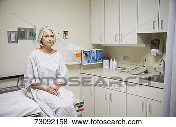 Stock Photo - senior female 
patient sitting 
on examination 
table, portrait. 
fotosearch - search 
stock photos, 
pictures, images, 
and photo clipart