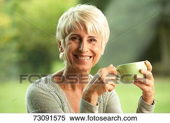Stock Image - senior woman holding 
teacup, smiling. 
fotosearch - search 
stock photos, 
pictures, images, 
and photo clipart