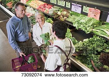 Stock Photo - shop assistant 
offering couple 
choice of vegetables. 
fotosearch - search 
stock photos, 
pictures, images, 
and photo clipart