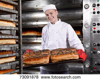 Stock Photo - teenage (16-17) 
baker presenting 
tray of fresh 
breads in bakery. 
fotosearch - search 
stock photos, 
pictures, images, 
and photo clipart