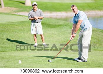 Stock Photo - two male golfers 
on golf course, 
one teeing off. 
fotosearch - search 
stock photos, 
pictures, images, 
and photo clipart