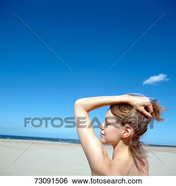 Stock Photo - woman holding 
back hair on beach. 
fotosearch - search 
stock photos, 
pictures, images, 
and photo clipart