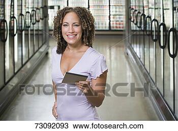 Stock Photo - woman holding 
pad in supermarket 
aisle, portrait. 
fotosearch - search 
stock photos, 
pictures, images, 
and photo clipart