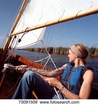 Stock Photograph - woman sailing 
sailboat on broads. 
fotosearch - search 
stock photos, 
pictures, images, 
and photo clipart