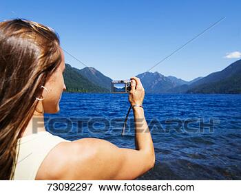 Picture - woman taking photo 
of lake, washington, 
usa. fotosearch 
- search stock 
photos, pictures, 
images, and photo 
clipart