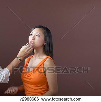 Stock Photo - young woman having 
make up applied 
by unseen make 
up artist. fotosearch 
- search stock 
photos, pictures, 
images, and photo 
clipart