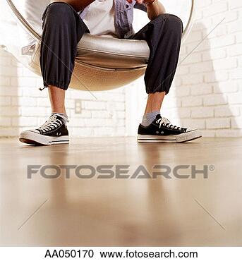 Stock Photography - low section of 
a man sitting 
in a spherical 
chair. fotosearch 
- search stock 
photos, pictures, 
images, and photo 
clipart