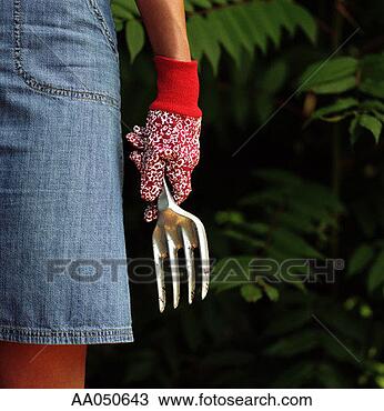 Stock Photo - woman with gardening 
glove and fork. 
fotosearch - search 
stock photos, 
pictures, images, 
and photo clipart