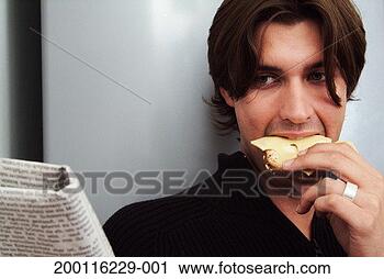 Stock Photography - young man reading 
newspaper eating 
bread and cheese. 
fotosearch - search 
stock photos, 
pictures, images, 
and photo clipart