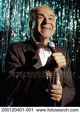 Stock Photography - mature man wearing 
tuxedo, standing 
on stage holding 
microphone. fotosearch 
- search stock 
photos, pictures, 
images, and photo 
clipart