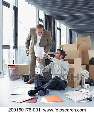 Stock Photography - businessman sitting 
against box showing 
colleague paperwork. 
fotosearch - search 
stock photos, 
pictures, images, 
and photo clipart