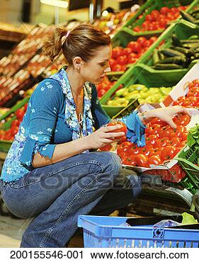 Stock Photography - woman shopping 
for tomatoes in 
grocery store, 
side view. fotosearch 
- search stock 
photos, pictures, 
images, and photo 
clipart