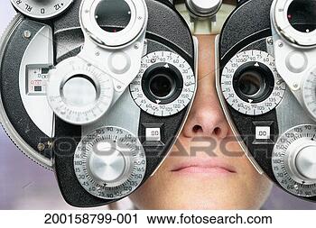 Stock Photography - young woman looking 
through phoropter 
during eye exam, 
close-up. fotosearch 
- search stock 
photos, pictures, 
images, and photo 
clipart