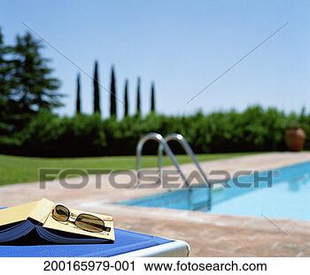 Stock Photography - book and sunglasses 
on sun lounger 
(focus on book 
and sunglasses). 
fotosearch - search 
stock photos, 
pictures, images, 
and photo clipart