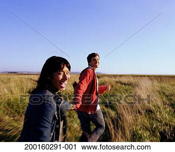 Stock Photography - couple running 
across field of 
tall grass (blurred 
motion). fotosearch 
- search stock 
photos, pictures, 
images, and photo 
clipart