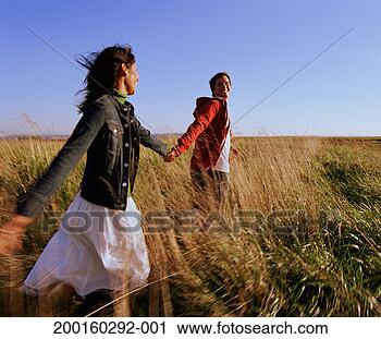 Stock Photography - couple running 
across field of 
tall grass (blurred 
motion). fotosearch 
- search stock 
photos, pictures, 
images, and photo 
clipart