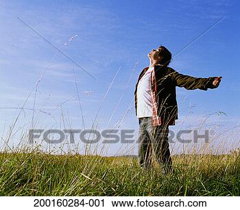 Stock Photography - man standing in 
field of tall 
grass, eyes closed, 
arms outstretched. 
fotosearch - search 
stock photos, 
pictures, images, 
and photo clipart