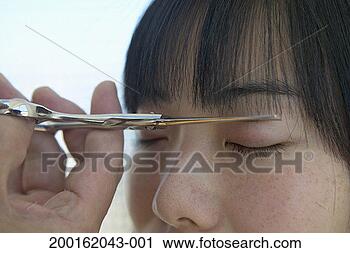Stock Photography - woman cutting 
front of hair 
with eyes closed, 
close-up. fotosearch 
- search stock 
photos, pictures, 
images, and photo 
clipart