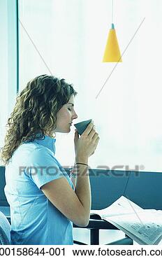 Stock Photography - woman reading 
newspaper and 
drinking coffee, 
side view. fotosearch 
- search stock 
photos, pictures, 
images, and photo 
clipart