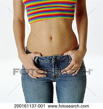 Stock Photography - young woman with 
thumbs hooked 
in jean's waist 
band, mid section. 
fotosearch - search 
stock photos, 
pictures, images, 
and photo clipart
