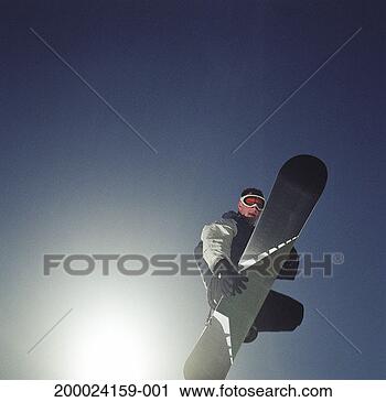 Stock Photography - young man jumping 
in mid air on 
snowboard, low 
angle view. fotosearch 
- search stock 
photos, pictures, 
images, and photo 
clipart