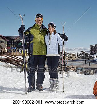 Stock Photography - couple carrying 
skis in ski field, 
smiling, portrait. 
fotosearch - search 
stock photos, 
pictures, images, 
and photo clipart