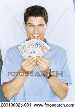 Stock Photography - man fanning euro 
banknotes, smiling, 
portrait. fotosearch 
- search stock 
photos, pictures, 
images, and photo 
clipart
