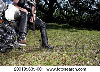 Stock Photography - mature man sitting 
on stationary 
motorbike, low 
section. fotosearch 
- search stock 
photos, pictures, 
images, and photo 
clipart